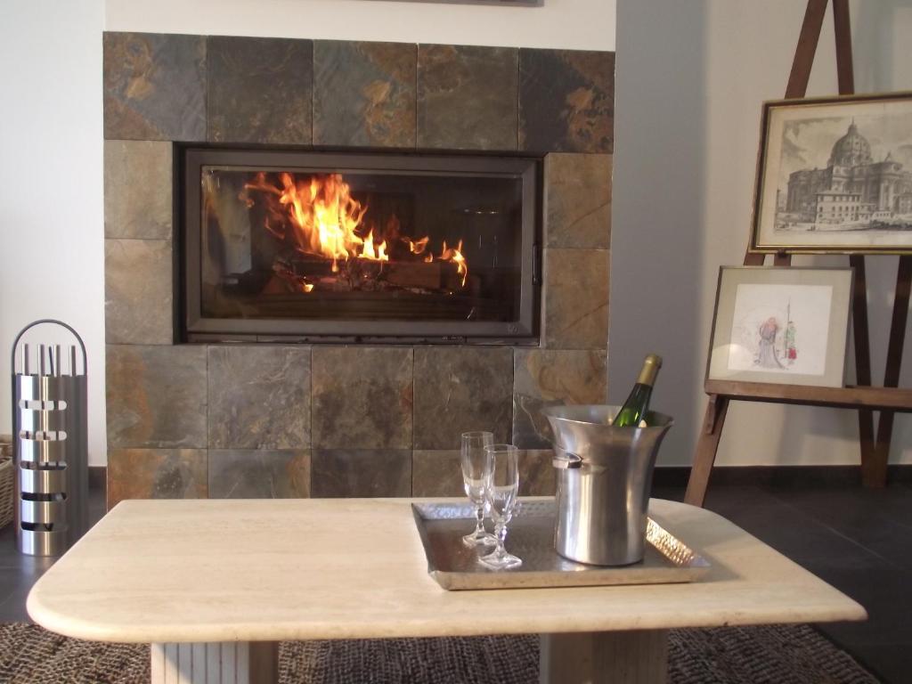 - une cheminée dans le salon avec une table et des verres à vin dans l'établissement Nature & Chateaux, à Villandry