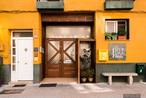 un bâtiment avec une porte et un banc devant lui dans l'établissement Albergue de la Piedra, à Villafranca del Bierzo