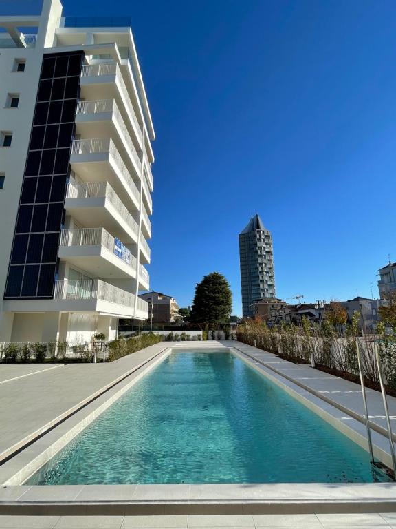 uma piscina em frente a um edifício em Blu Homes Apartments EfStyle Hotel em Lido di Jesolo