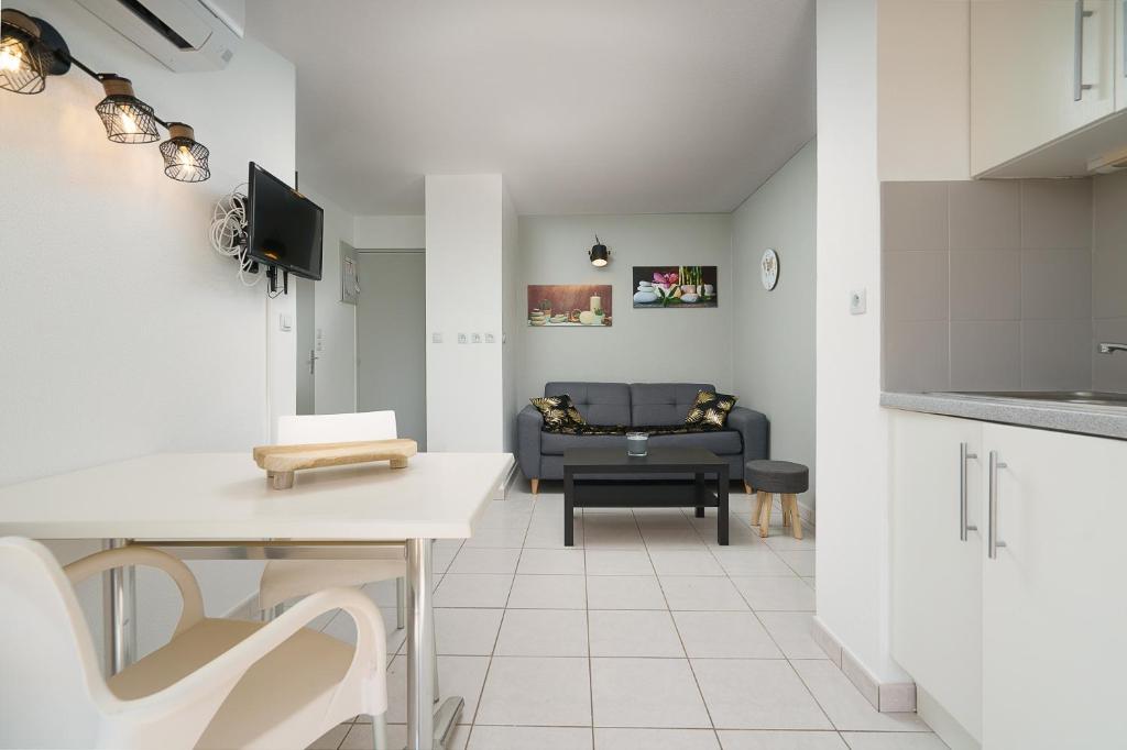 a kitchen and a living room with a couch at appartement 2p PRIMAVERA in Cap d'Agde