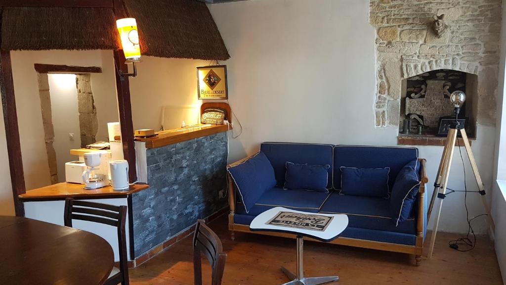 a living room with a blue couch and a table at Maison de bourg à Ouistreham à 2 pas de la mer in Ouistreham