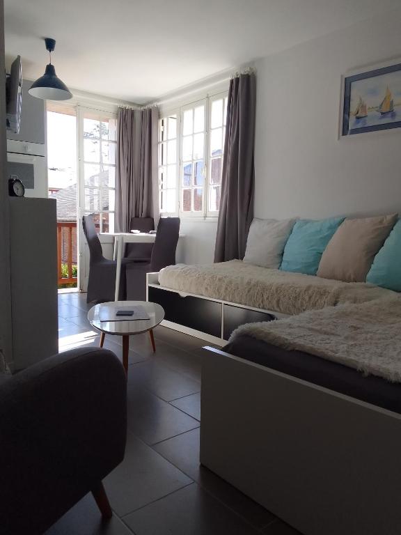 une chambre d'hôtel avec deux lits et une table dans l'établissement Les cigognes, à Bagnoles-de-l'Orne