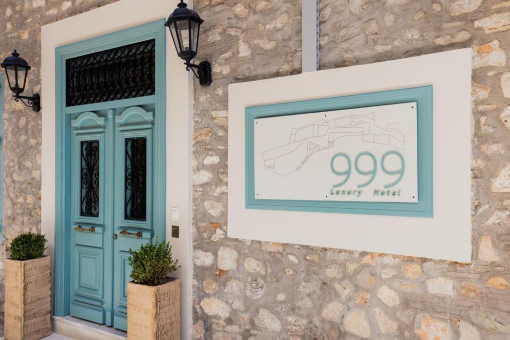eine Wand mit einer blauen Tür und einem Bild darauf in der Unterkunft 999 Luxury Hotel in Nafplio