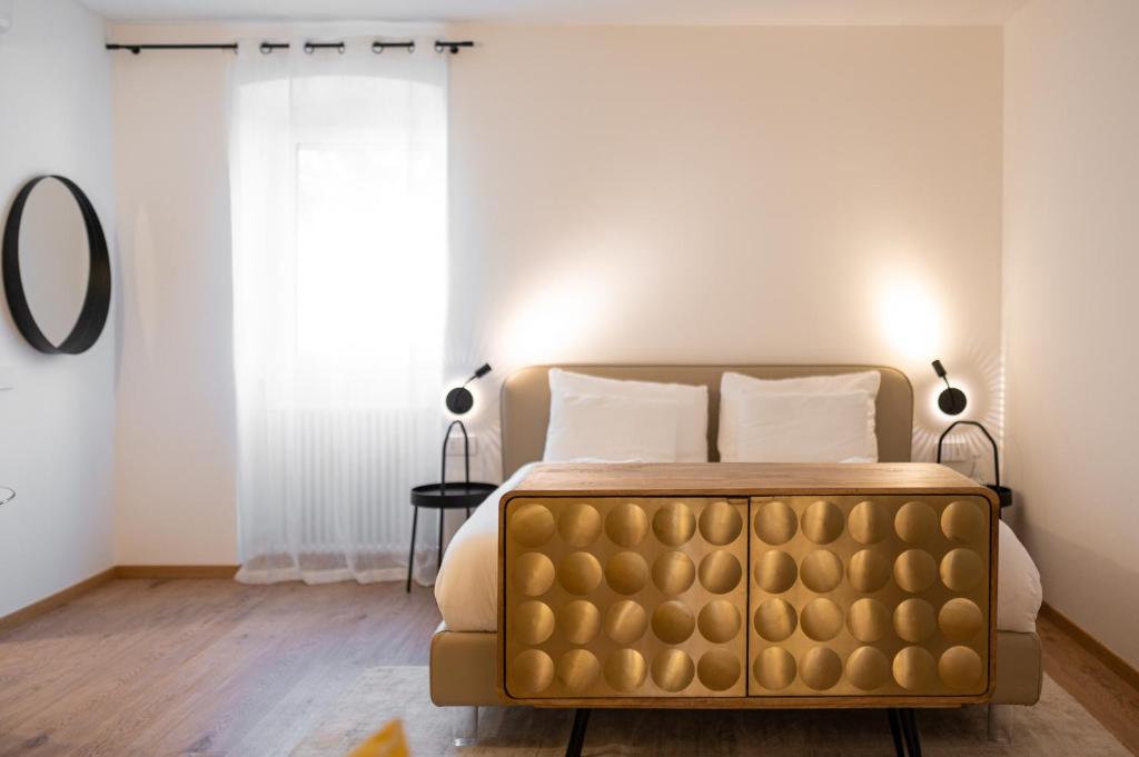 - une chambre avec un lit doré et une fenêtre dans l'établissement Guesthouse diWINE, à Merano