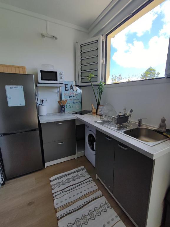 uma cozinha com um lavatório, um frigorífico e uma janela em Joli T2 rénové et calme Quartier desrochers à Fort de France em Fort-de-France
