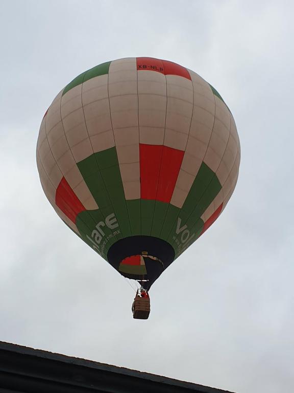 a hot air balloon flying in the sky at Sol y Luna Teotihuacan in San Sebastian Xolalpa