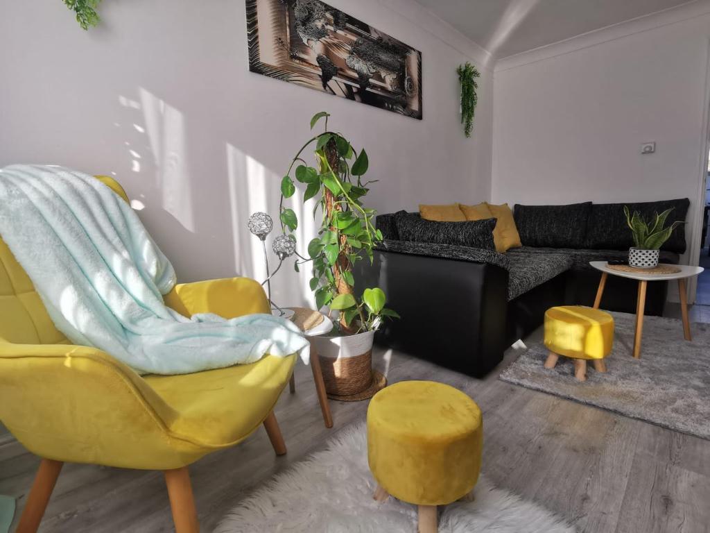 a living room with a yellow chair and a couch at Benjamin Gardens Holiday Home in Great Driffield