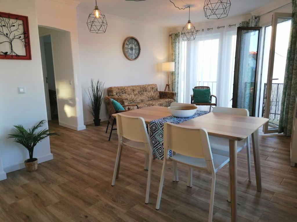 comedor y sala de estar con mesa y sillas en Apartamento Vilamar en Vila Nova de Milfontes