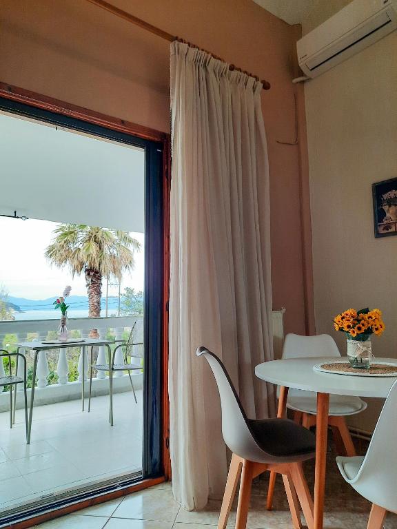 sala de estar con mesa y ventana grande en Aktaia Villa, en Ierissos