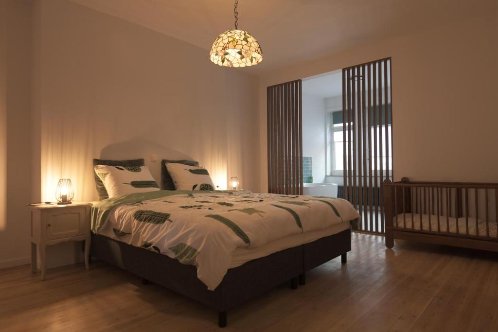 1 dormitorio con cama y lámpara de araña en Gastenkamers huYze K, en Zottegem