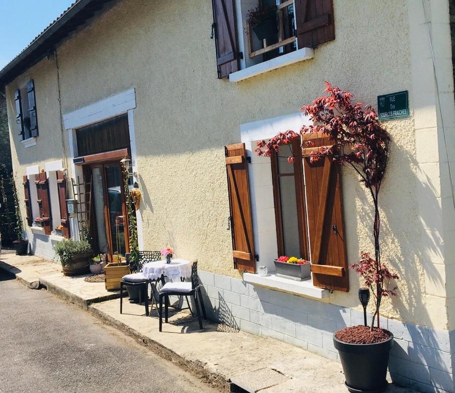 un edificio con una mesa y sillas fuera de él en Maison Blanche De Hudson en Cussac