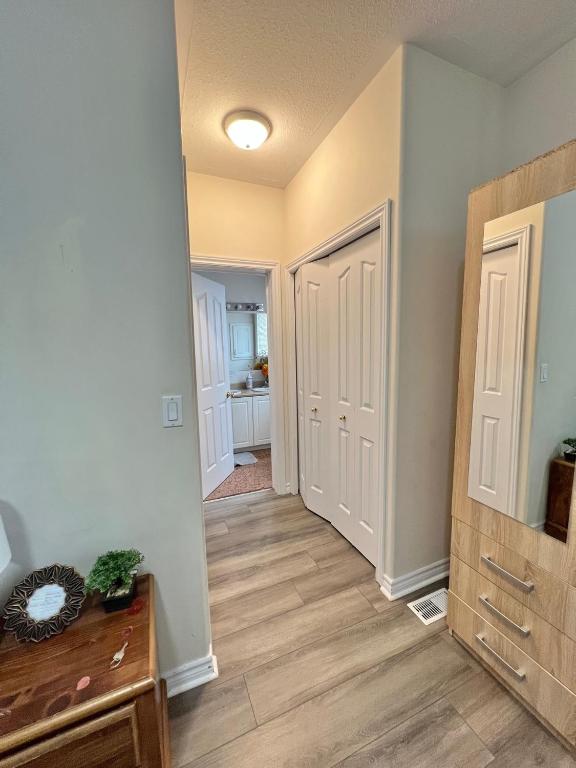 a hallway of a home with white walls and wooden floors at May Flowers in Kingston