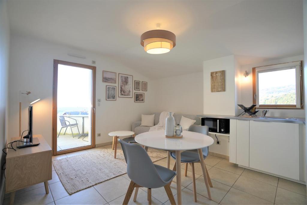 a kitchen and living room with a table and chairs at STUDIO dernier étage avec terrasse - vue montagne in Cruseilles