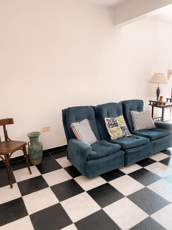 a blue couch in a living room with a checkered floor at Casa Moreno in Belén de Escobar