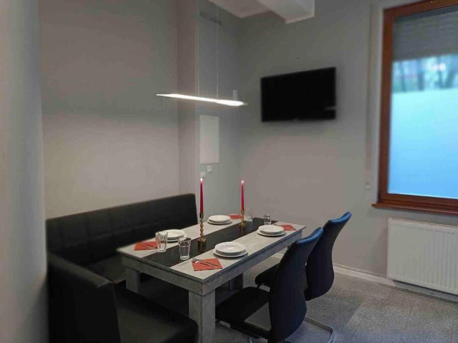 a dining room with a table with chairs and a television at City-Apartment Sorgenfrei in Berlin