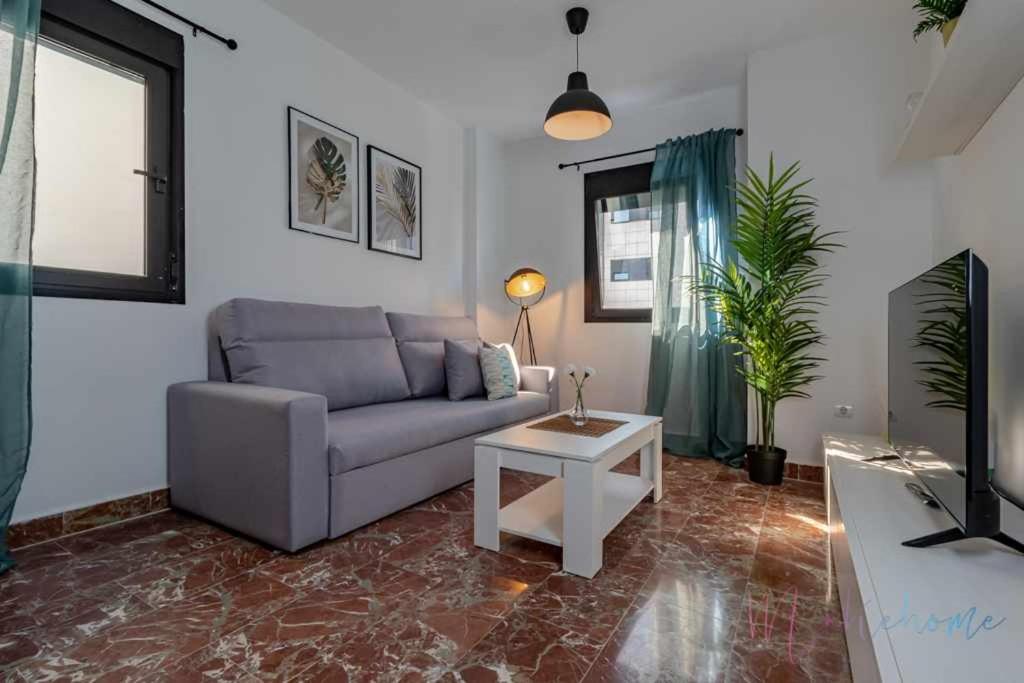 un soggiorno con divano e tavolo di Dos dormitorios nuevo pleno centro con garaje a Huelva