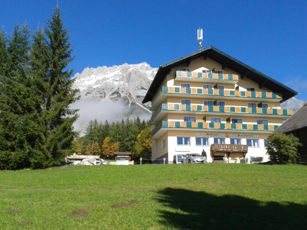 a large building with a mountain in the background at Apartman Ramsau in Ramsau am Dachstein