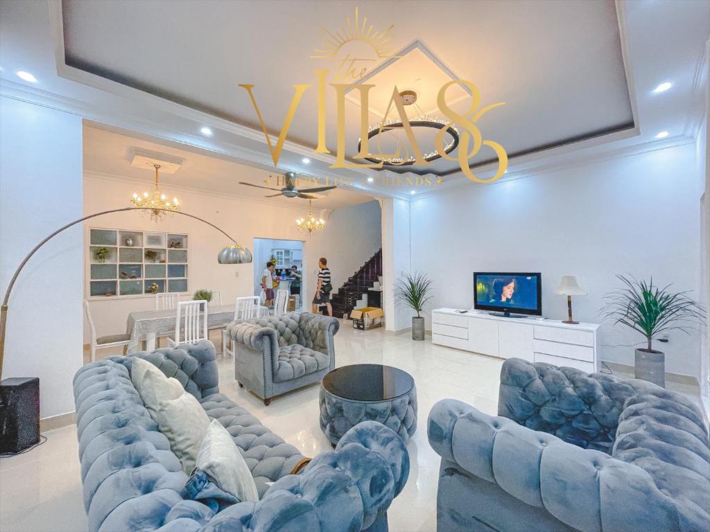 a living room with blue couches and a flat screen tv at Villa 90 - Villa 86 Group in Ho Chi Minh City