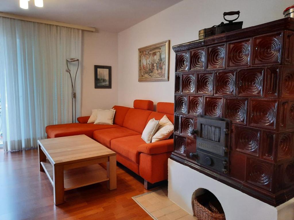 salon z pomarańczową kanapą i kominkiem w obiekcie Holiday Home Marija w mieście Vantačići