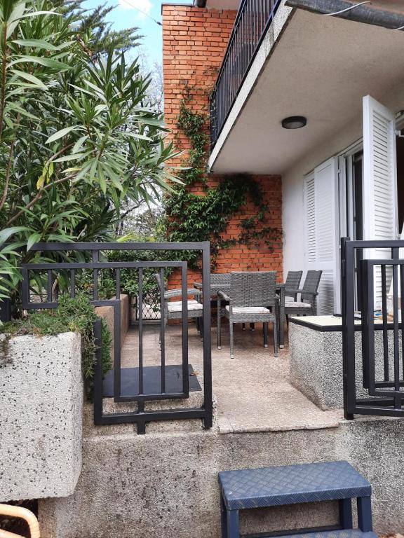 patio z krzesłami, stołem i ogrodzeniem w obiekcie Holiday Home Marija w mieście Vantačići