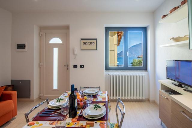 uma sala de estar com uma mesa e uma televisão em casa Matisse em Pianello Del Lario