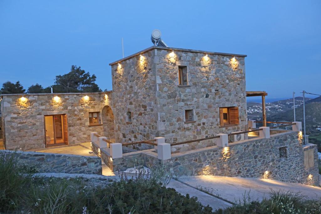a stone house with lights on the side of it at Picollo Grecia Residence Panoramic View in Ermoupoli