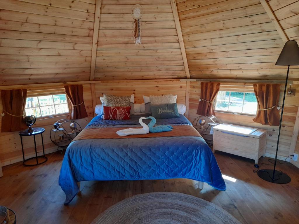 een slaapkamer met een bed met een zwaan erop bij A l'orée du Cèdre in Pouzauges