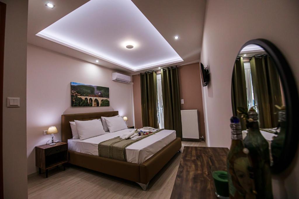 a bedroom with a large bed and a mirror at Helena's apartment two in Volos