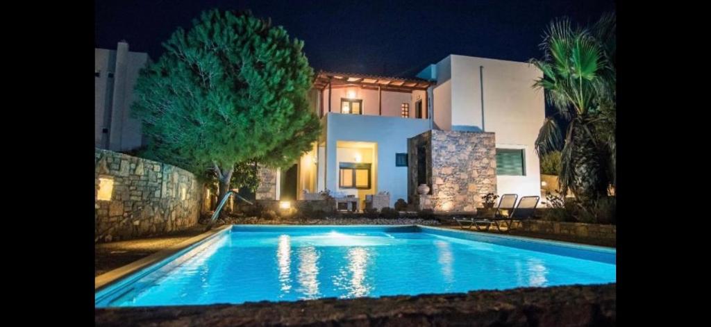a swimming pool in front of a house at night at Luxury Villa in Agios Nikolaos with private pool in Agios Nikolaos