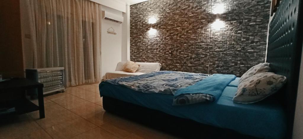 a bedroom with a bed and a brick wall at Studio near the port !!! in Paralia Katerinis