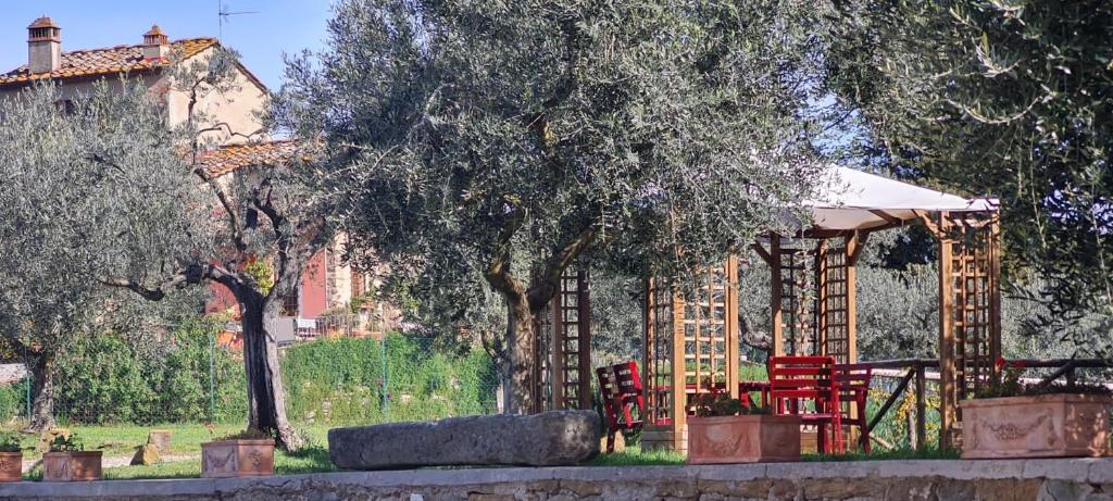 a house with a gazebo and red chairs at Agriturismo Il Pintello in San Casciano in Val di Pesa