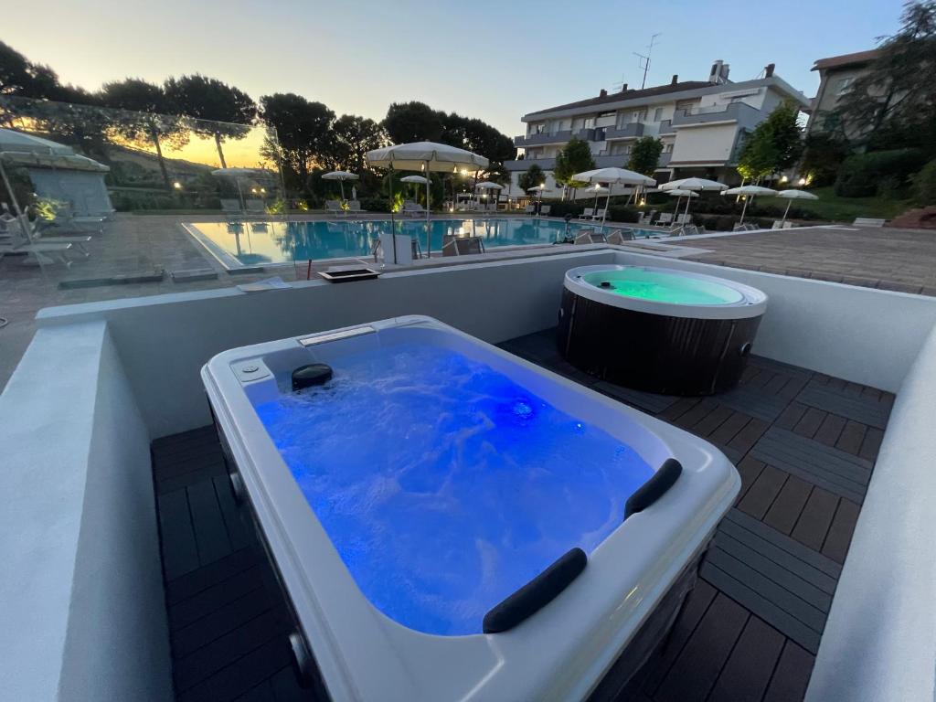 a bath tub sitting on a deck next to a pool at Pineto Resort in Pineto