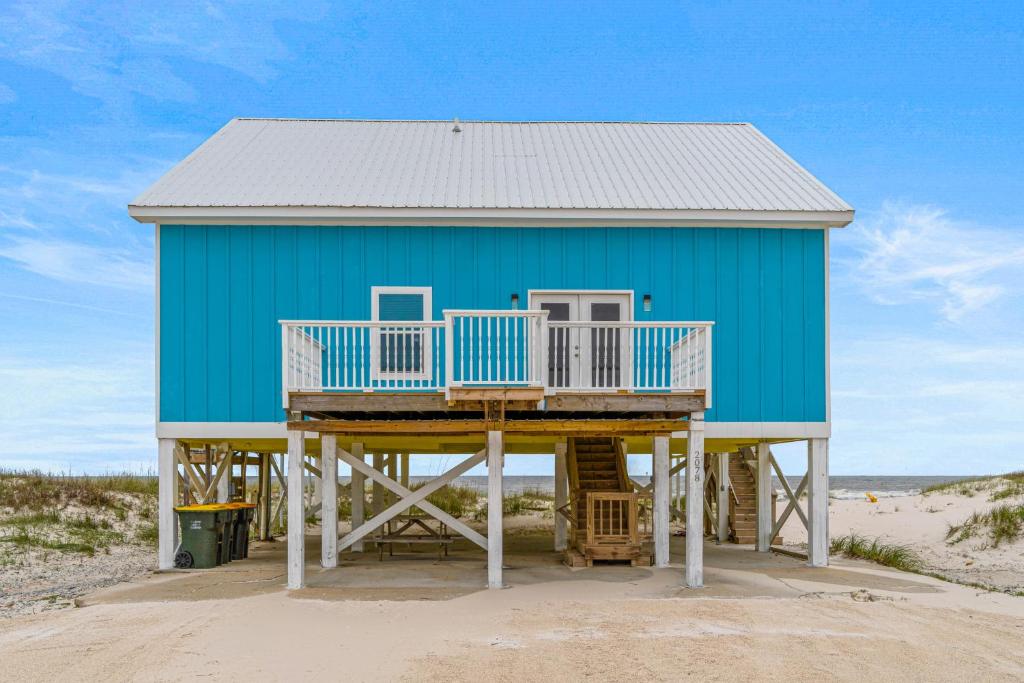 una casa azul en la playa en la arena en The Blue Whale en Gulf Shores