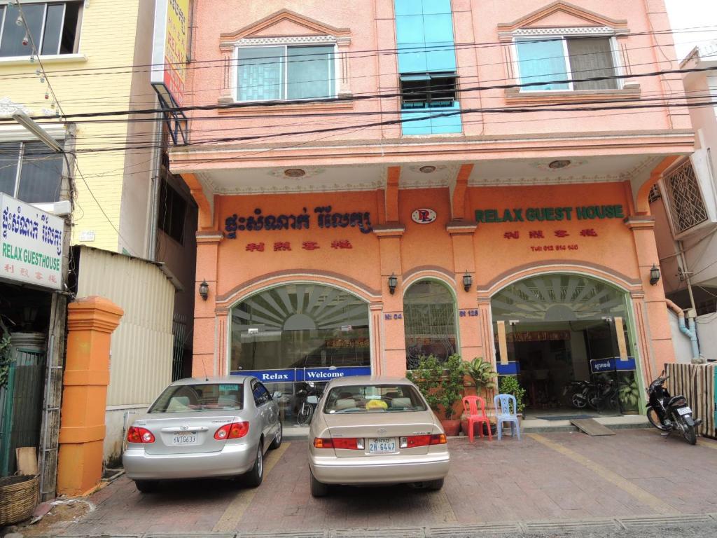 two cars parked in front of a building at Relax Guesthouse in Phnom Penh
