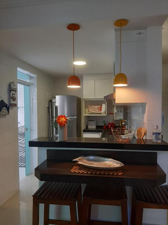 una cucina con bancone, due sedie e un tavolo di Apartamento Top Praça da Bandeira - Praia do Forte a Cabo Frio