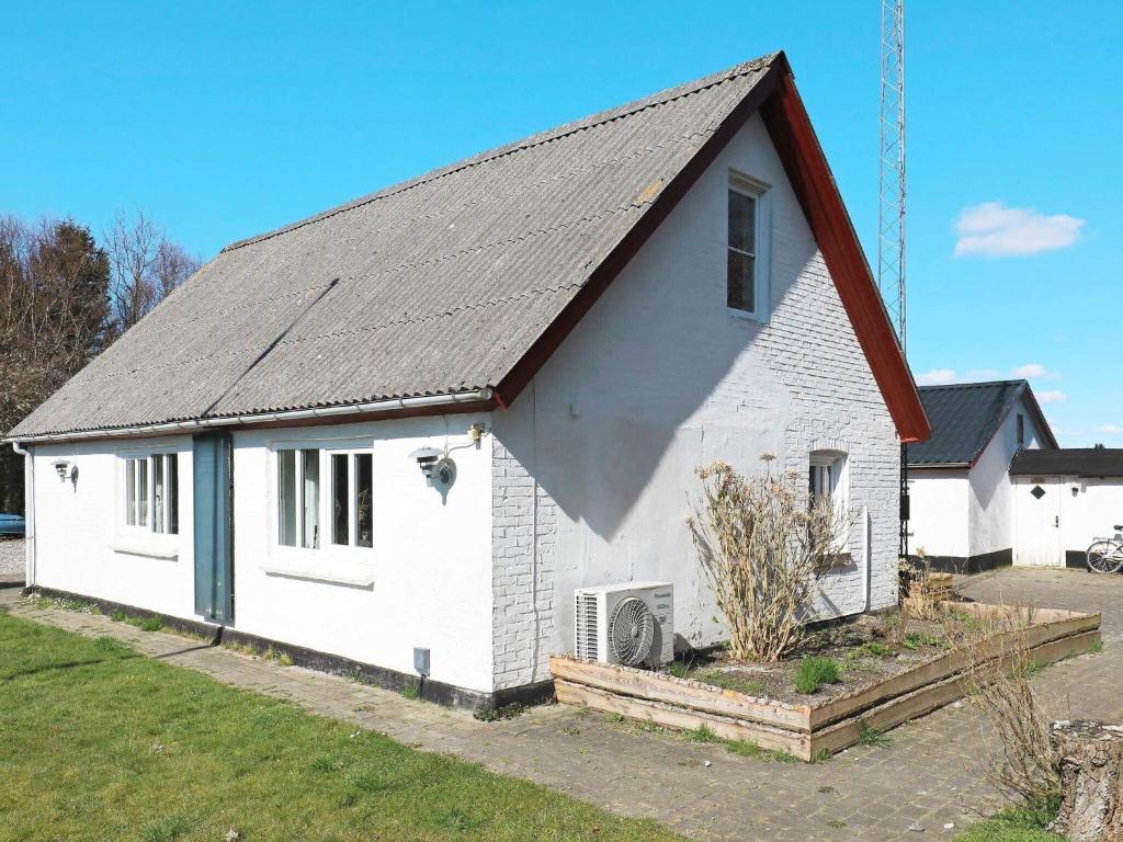 una casa blanca con techo negro en Luxurious Holiday Home in Thyholm with Sauna en Thyholm