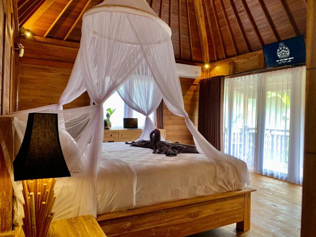 um quarto com uma cama e uma rede mosquiteira em Aix Cottage Ubud em Ubud