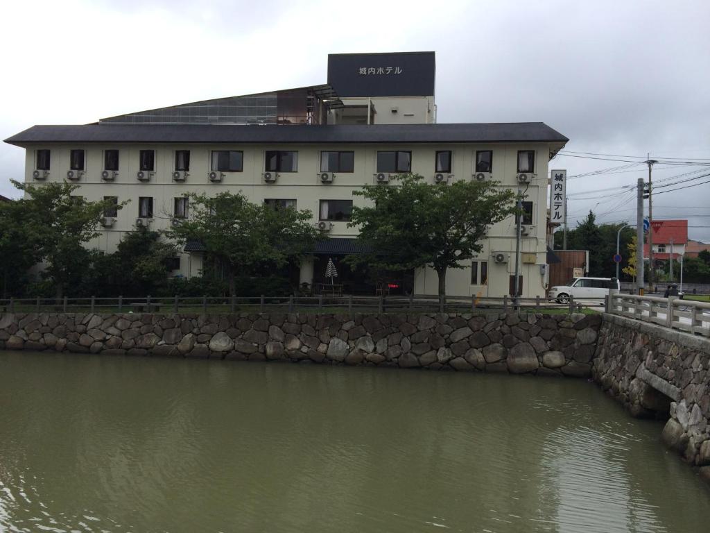 un edificio sentado junto a un cuerpo de agua en Jonai Hotel en Karatsu
