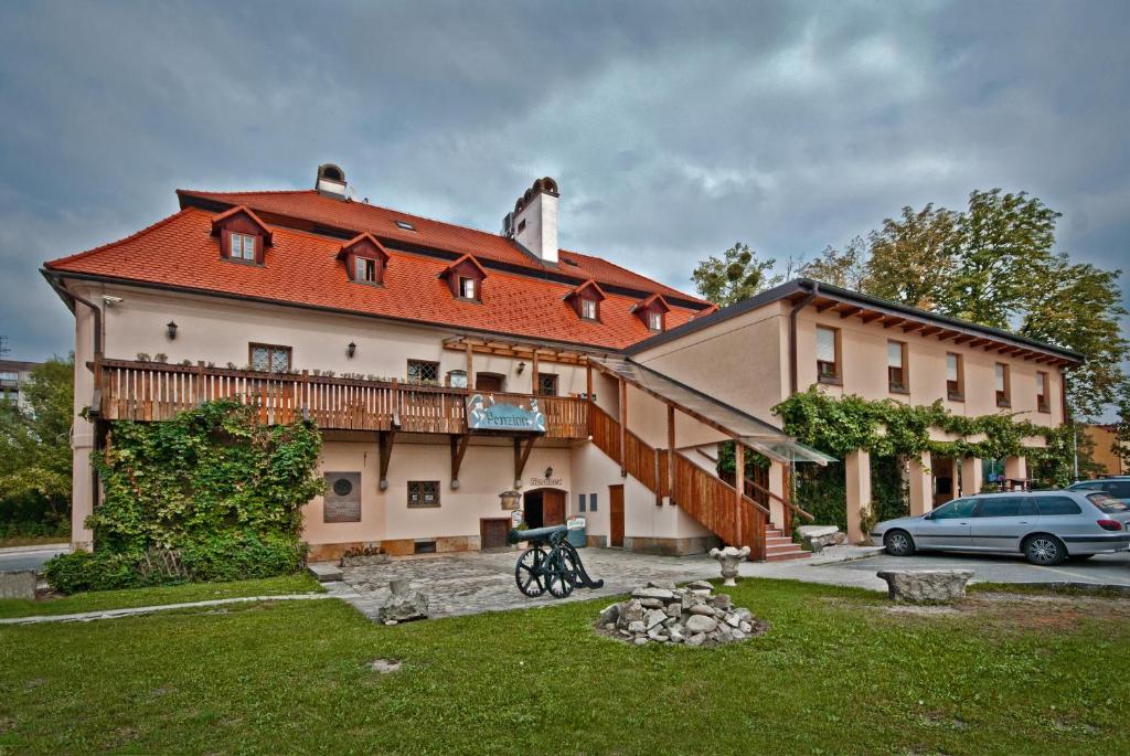 une grande maison avec un toit rouge et une cour dans l'établissement Penzion U Kriveho psa, à Frýdek-Místek
