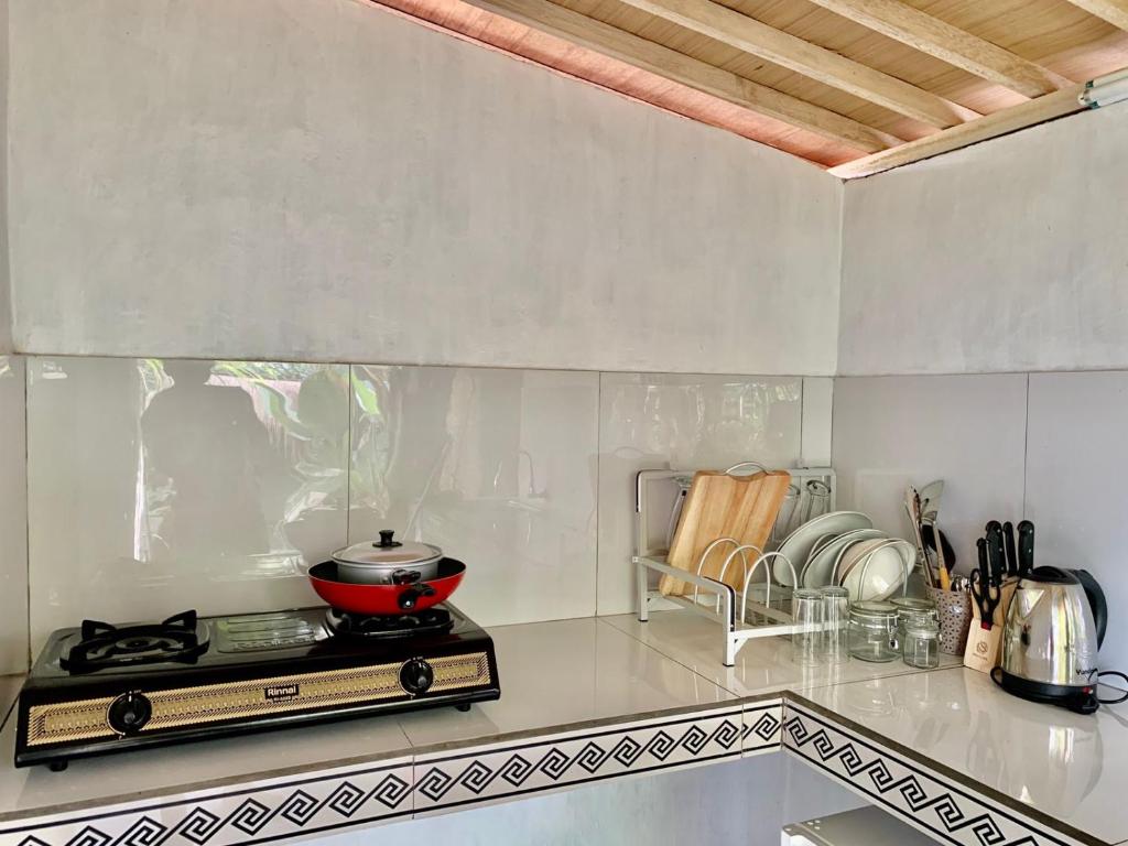 una cucina con piano cottura e pentola di Aix Cottage Ubud ad Ubud