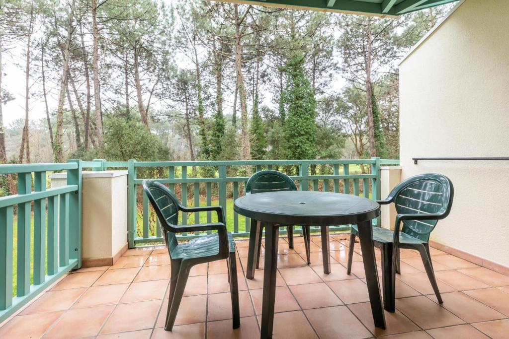 un patio avec une table et des chaises sur un balcon dans l'établissement Le Domaine du Golf de Pinsolle - maeva Home - Appartement 2 pièces 5 personnes - Confort MAE-7574, à Soustons