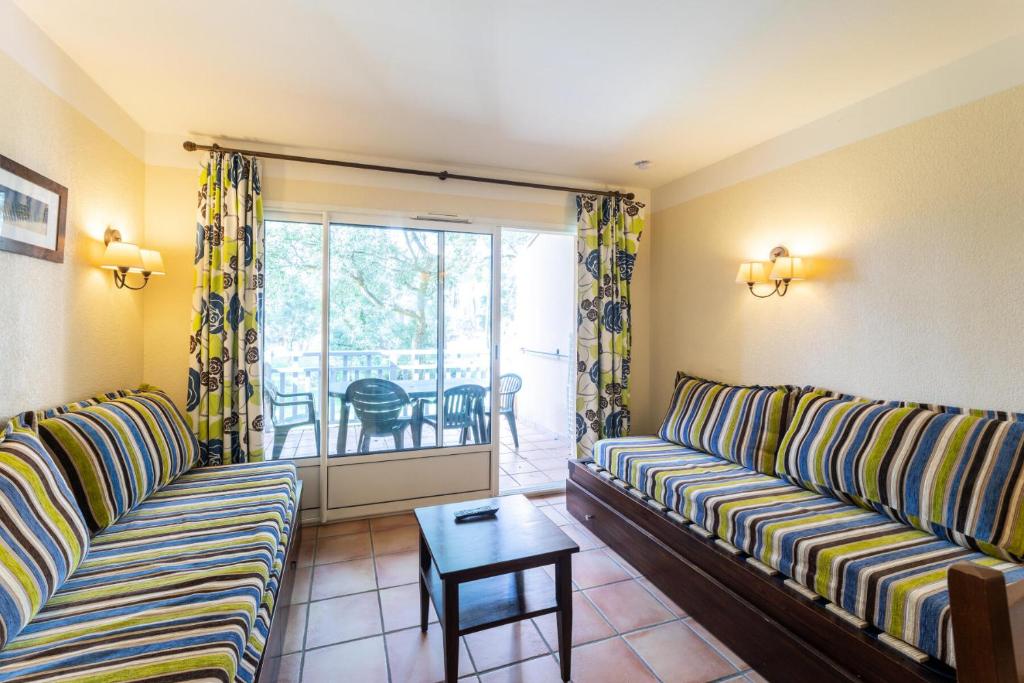 ein Wohnzimmer mit 2 Sofas und einem Tisch in der Unterkunft Le Domaine du Golf de Pinsolle - maeva Home - Appartement 2 pièces 5 person 674 in Soustons