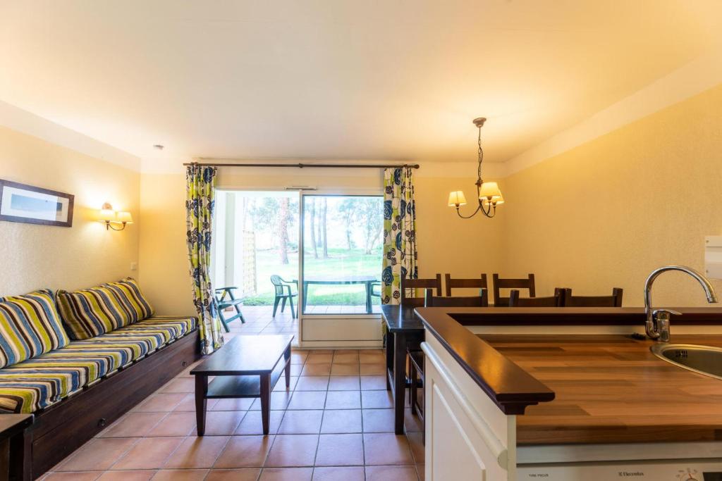 une cuisine et un salon avec un canapé et une table dans l'établissement Le Domaine du Golf de Pinsolle - maeva Home - Appartement 2 pièces 6 personnes - Confort MAE-2684, à Soustons