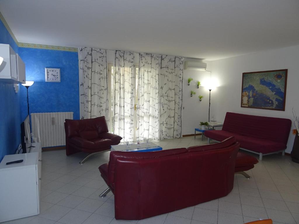 ein Wohnzimmer mit 2 Stühlen, einem Sofa und einem Tisch in der Unterkunft La Martlona in Riccione