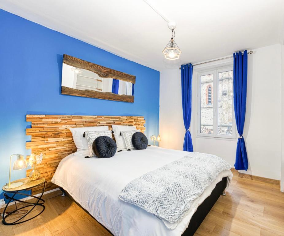 a bedroom with a large bed with blue walls at Élégance contemporaine près des Thermes. in Allevard