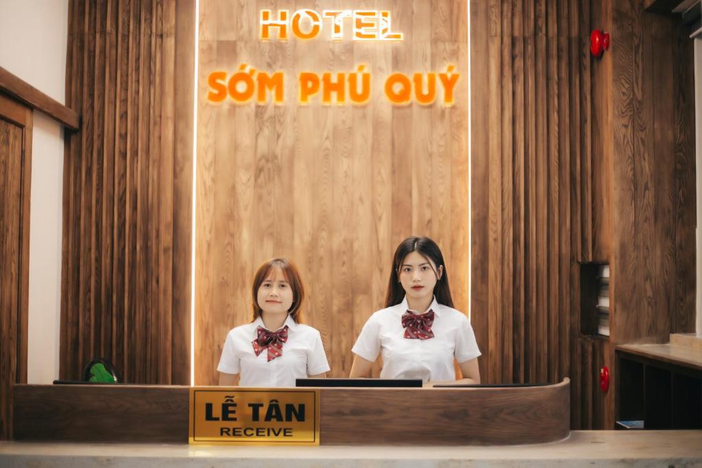 two women standing at a desk in a hotel at Khách sạn Sớm Phú Quý - Ninh Thuận in Phan Rang