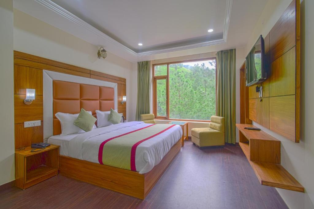 sypialnia z dużym łóżkiem i oknem w obiekcie Hotel The Paal w mieście Shimla