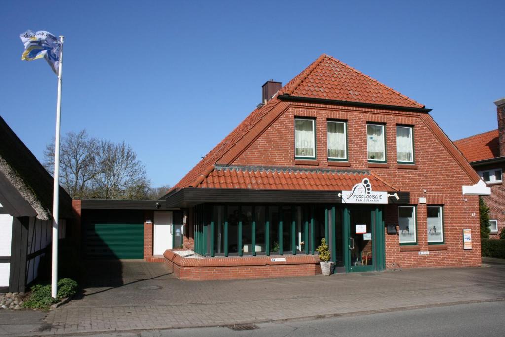 ein Backsteingebäude mit einer Flagge davor in der Unterkunft "Alte Sparkasse" Nr1 in Landkirchen