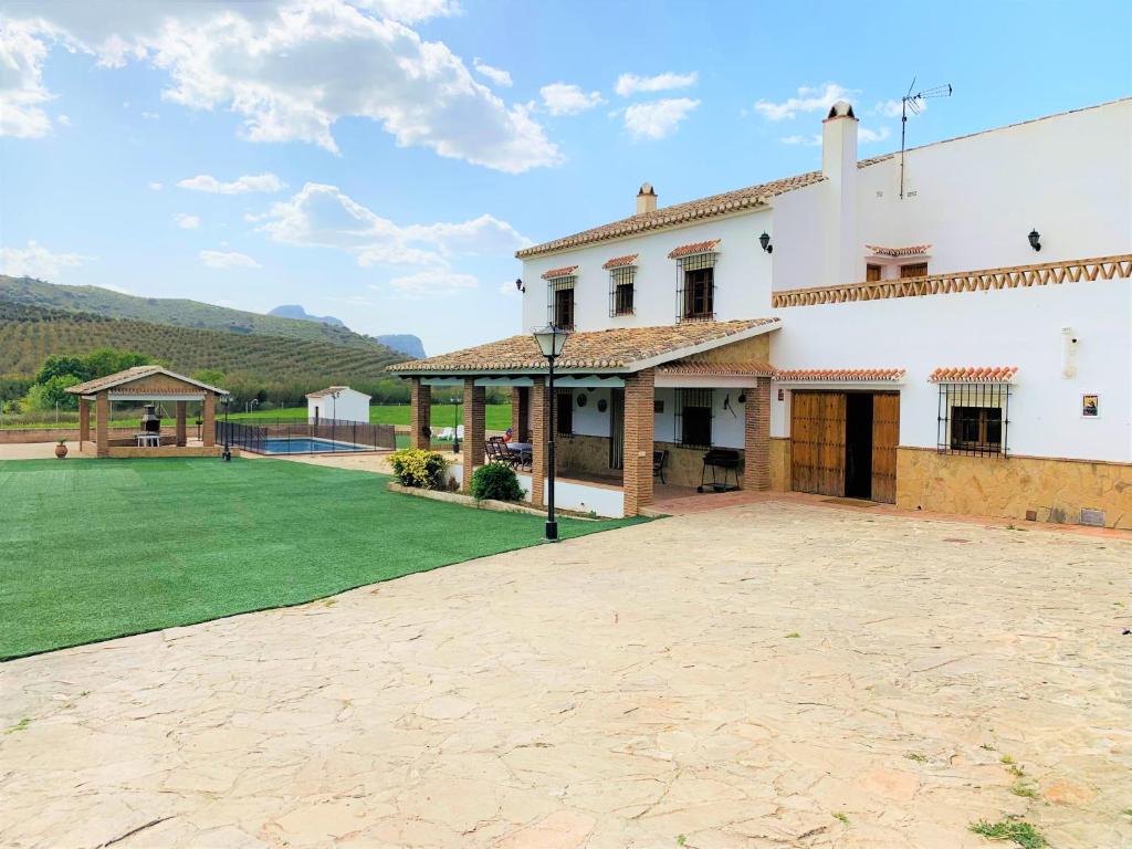 una gran casa blanca con un gran patio en Casa Rural Huerta Abuela María en Archidona