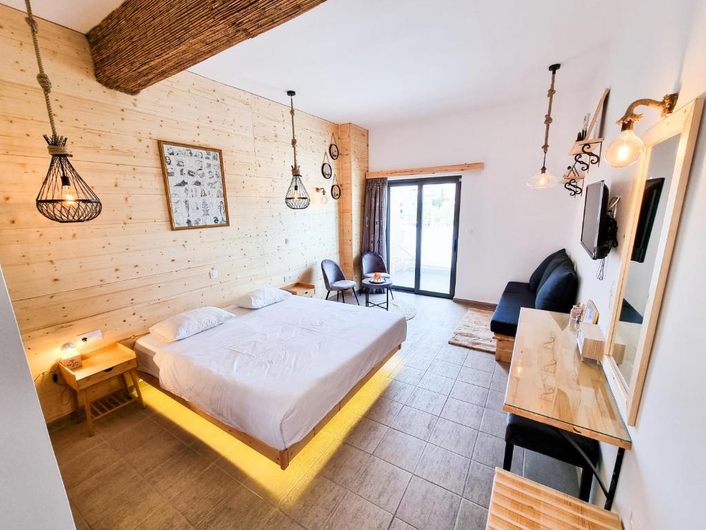 een slaapkamer met een bed en een woonkamer bij Penélope Hotel in Ialyssos